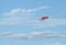 Red retro airplane in the blue sky during airshow, airplane trail