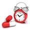 Red retro alarm clock and big medicine pills