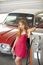 Red retro automobile. Old American Car. Gas station girl. Woman refuel the auto.