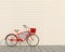 Red retro bicycle with basket in front of the white wall, background