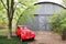 Red retro small vintage car standing in the garden in the summer