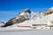 The red Rhaetian Rail is passing along the frozen Lake Bianco