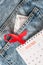 Red ribbon, calendar and condom on jeans. World AIDS Day