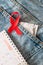 Red ribbon, calendar and condom on jeans. World AIDS Day