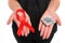Red ribbon and a condom on female hands isolated on a white background. AIDS Awareness. Healthcare and medicine concept