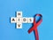 Red ribbon with crosswords aids and hiv against blue background.