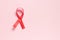 Red ribbon on a pink background. The concept of medicine and human health care. World breast cancer awareness and