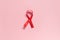 Red ribbon on a pink background. The concept of medicine and human health care. World breast cancer awareness and prevention day