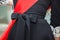 Red ribbon and a schoolgirl`s belt tied with a bow close-up. Elements of strict school uniform at the graduation and the last cal