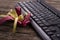 Red ribbon on top of wooden near black Keyboard - very shallow depth of field.