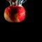 Red ripe Apple falls into the water with splashes