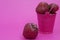 Red ripe fresh strawberries on a pink background lies in a pink bucket. spilled from a bucket of ripe strawberries.