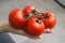 Red ripe juicy tomatoes lie on the palm of your hand. The hand holds a bunch of tomatoes. Vegetables for cooking.