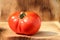 Red ripe large tomato on wooden background.