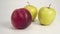 Red ripe nectarine on a background of green ripe autumn apples on a white background.