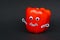 Red ripe paprika with funny goggle eyes, stick hands and happy smiling mouth isolated on black background