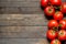 Red ripened tomatoes on wooden background with copy space in left part