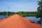 Red road to the waterfall in Cambodia