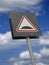RED ROAD TRAFFIC SPEED BUMP SIGN ON BLUE SKY AND CLOUD BACKGROUND