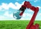 Red robot claw holding globe against green grass field and sky