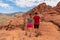 Red Rock Canyon - Couple standing on rocks with scenic view of Aztec sandstone slickrock outcrop on the Calico Hills Tank Trail