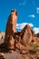Red rock formation of sandstone boulders beneath a beautiful blue sky with fluffy white clouds