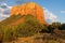 Red rock sandstone rock formation glows gold in the light of sunset