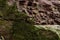 Red rock wall of ravine with green moss closeup