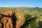 Red Rocks, Coniferous Forest and Mountains on Background. Aerial View