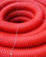 Red rolled up wire pipe on an industrial construction site