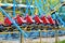 Red rollercoaster riding on blue and yellow railroad against blue sky in the amusement park