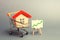 A red roof house in a trading cart and green arrow up on a stand. Increasing the cost and liquidity of real estate. Attractive