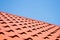 Red roof of metal roofing on the sky background