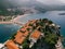 Red roofs of houses among greenery on the island of Sveti Stefan. Drone