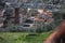 The red roofs of the inhabited houses, the church and the bell tower of the pietrasanta cathedral seen from the green of a hill at