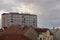 Red roofs and pink apartment building. Prefabricated house. Windows, balconies, roofs and chimneys