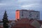 Red roofs and pink apartment building. Prefabricated house. Windows, balconies, roofs and chimneys