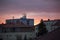 Red roofs and pink apartment building. Prefabricated house. Windows, balconies, roofs and chimneys