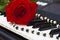 Red rose and bead on piano keys