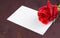 Red rose and blank gift card for text on old wood background
