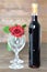 Red rose, bottle of red wine and two wine glasses