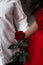 Red rose in couple hands, sent roses represent love on Valentine\'s Day. Anniversary proposal and engagement idea. Part body man