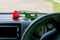 A red rose flower lies on the dashboard in the car