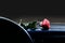 Red rose flower lies at night by moonlight on the dashboard inside the car
