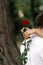 Red rose in hand, sent roses represent love on Valentine\'s Day. Anniversary proposal and engagement idea. Part body man with one