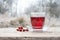 Red rose hip tea and some fruits outdoors on a rustic wooden table, healthy and warming hot drink on a cold winter day, copy space