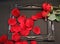 Red rose and loose leaves are arranged in a chic old black picture frame on a black background