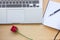 Red rose, notebook, pencil and laptop on wooden table for love c