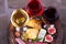 Red, rose and white glasses and bottles of wine. Cheese, fig, grape, prosciutto and bread on old wooden barrel. View from above