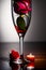 a red rose with white and red petals stands in a tall glass goblet